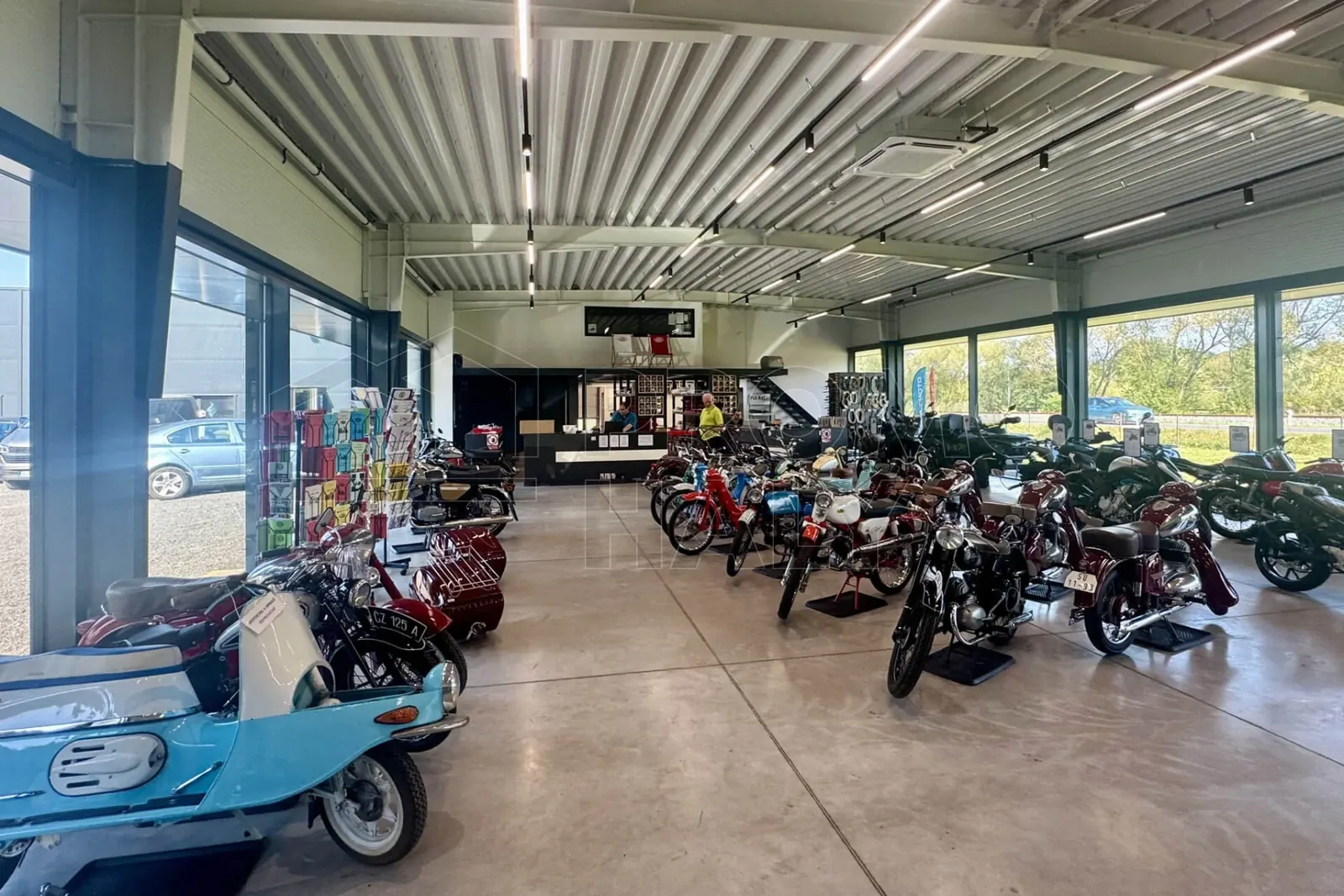 Prodejna MV Díly, pult a řada historických motocyklů